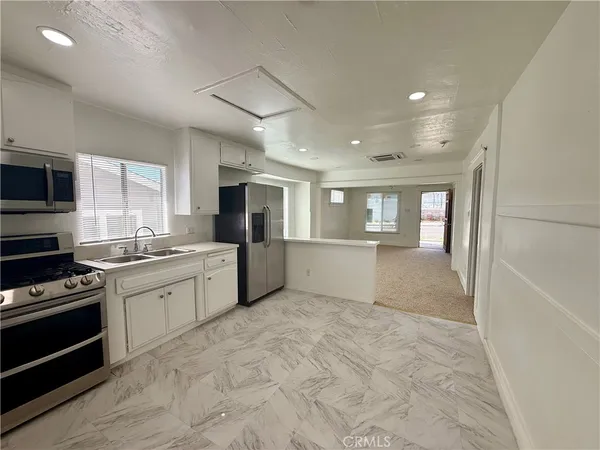a large kitchen with cabinets and stainless steel appliances