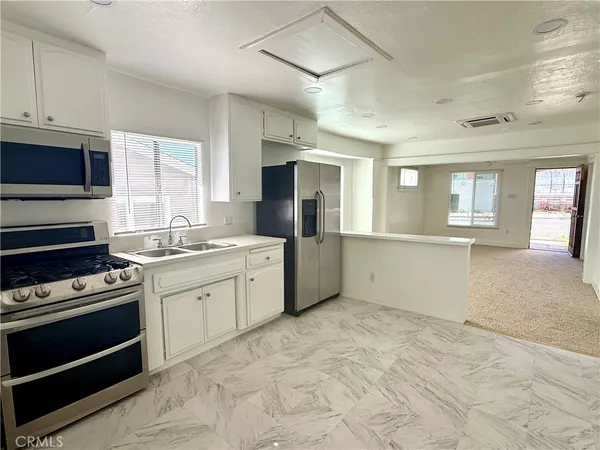 a kitchen with granite countertop a stove top oven and cabinets