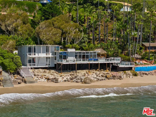 a view of swimming pool with lawn chairs and ocean view