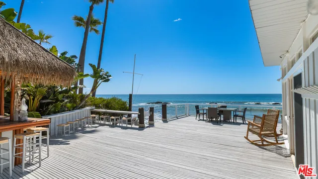 a view of a balcony with chairs and wooden floor
