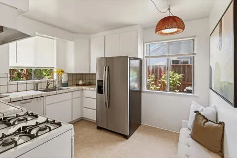 a kitchen with a refrigerator and a stove top oven
