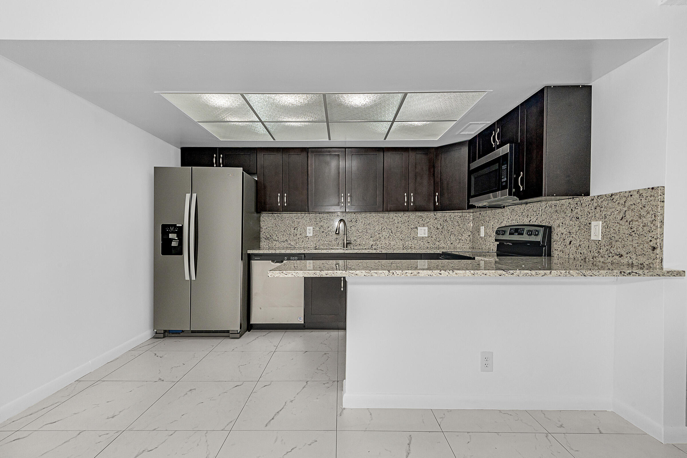 8706 West Sample Road, Unit 4 Coral Springs, FL 33065 - Photo 3 of 21 a kitchen with stainless steel appliances granite countertop a refrigerator and a stove