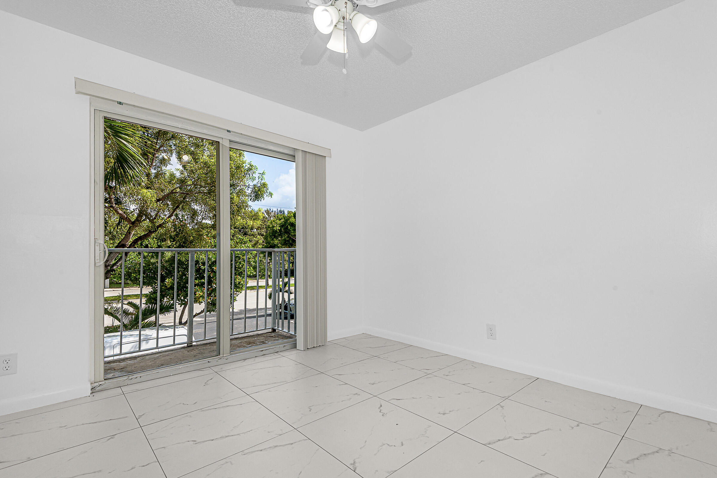 8706 West Sample Road, Unit 4 Coral Springs, FL 33065 - Photo 8 of 21 en empty room with wooden floor and sliding door