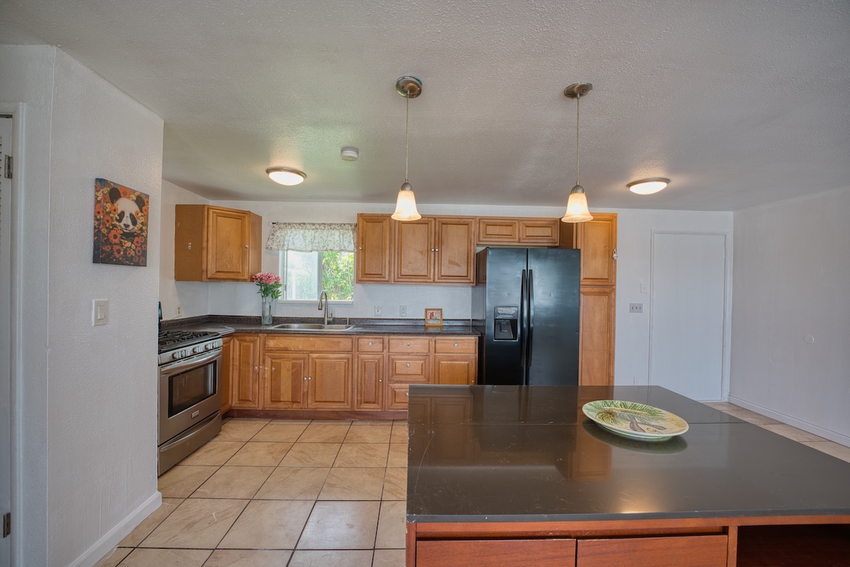 2059 Kinoole Street Hilo, HI 96720 - Photo 15 of 30 a kitchen with stainless steel appliances granite countertop a refrigerator and a stove
