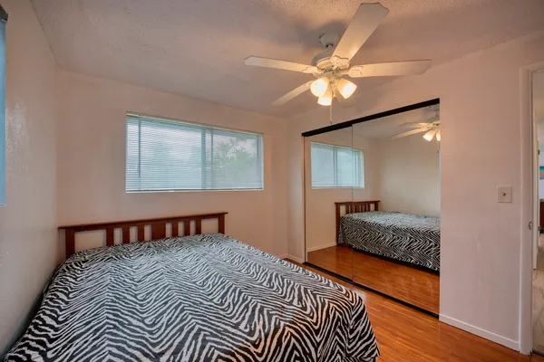 a bedroom with a bed and wooden floor