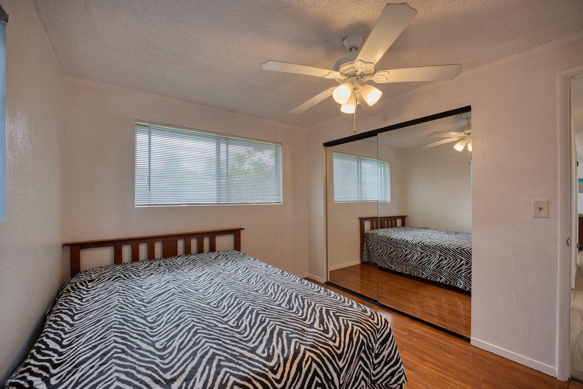2059 Kinoole Street Hilo, HI 96720 - Photo 18 of 30 a bedroom with a bed and wooden floor