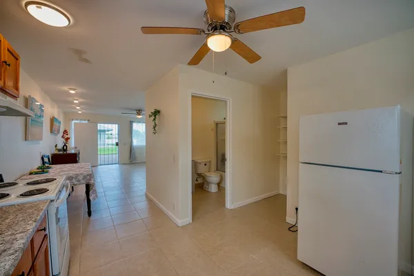 a view of a kitchen with a refrigerator and a ceiling fan