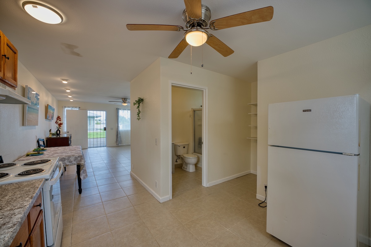 2059 Kinoole Street Hilo, HI 96720 - Photo 8 of 30 a view of a kitchen with a refrigerator and a ceiling fan