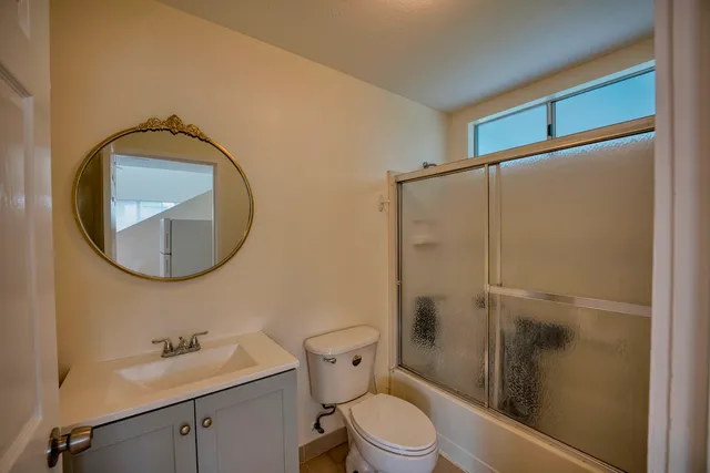 a bathroom with a toilet a sink and a mirror