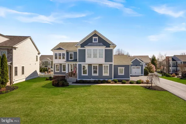 a front view of a house with a garden and lake view