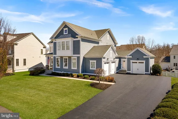 a view of a house with a big yard and large trees