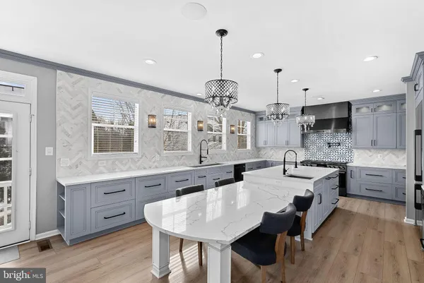 a large kitchen with kitchen island a island a sink a stove and wooden floor