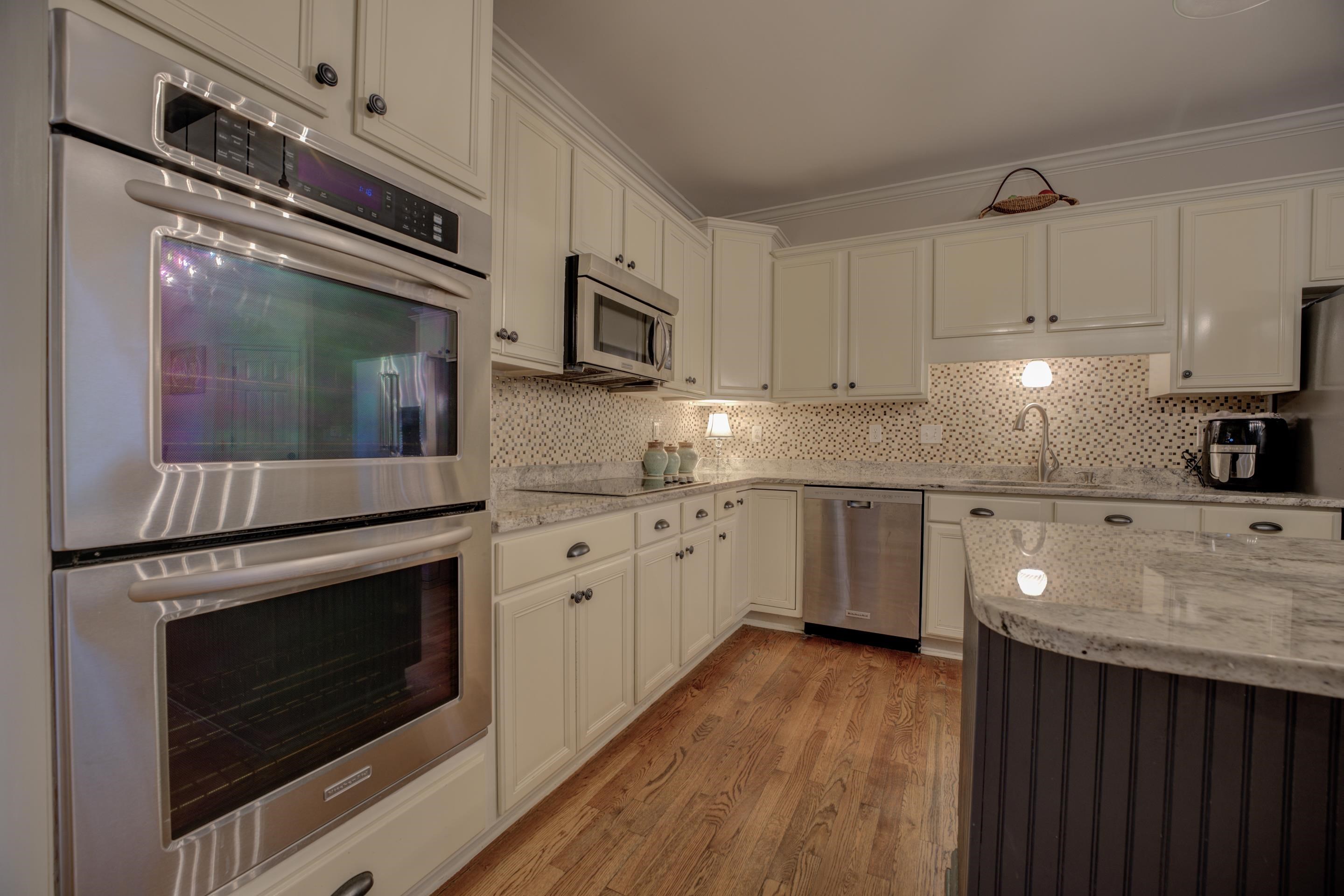 9852 Garden Place Collierville, TN 38139 - Photo 11 of 38 a kitchen with granite countertop white cabinets stainless steel appliances and wooden floor