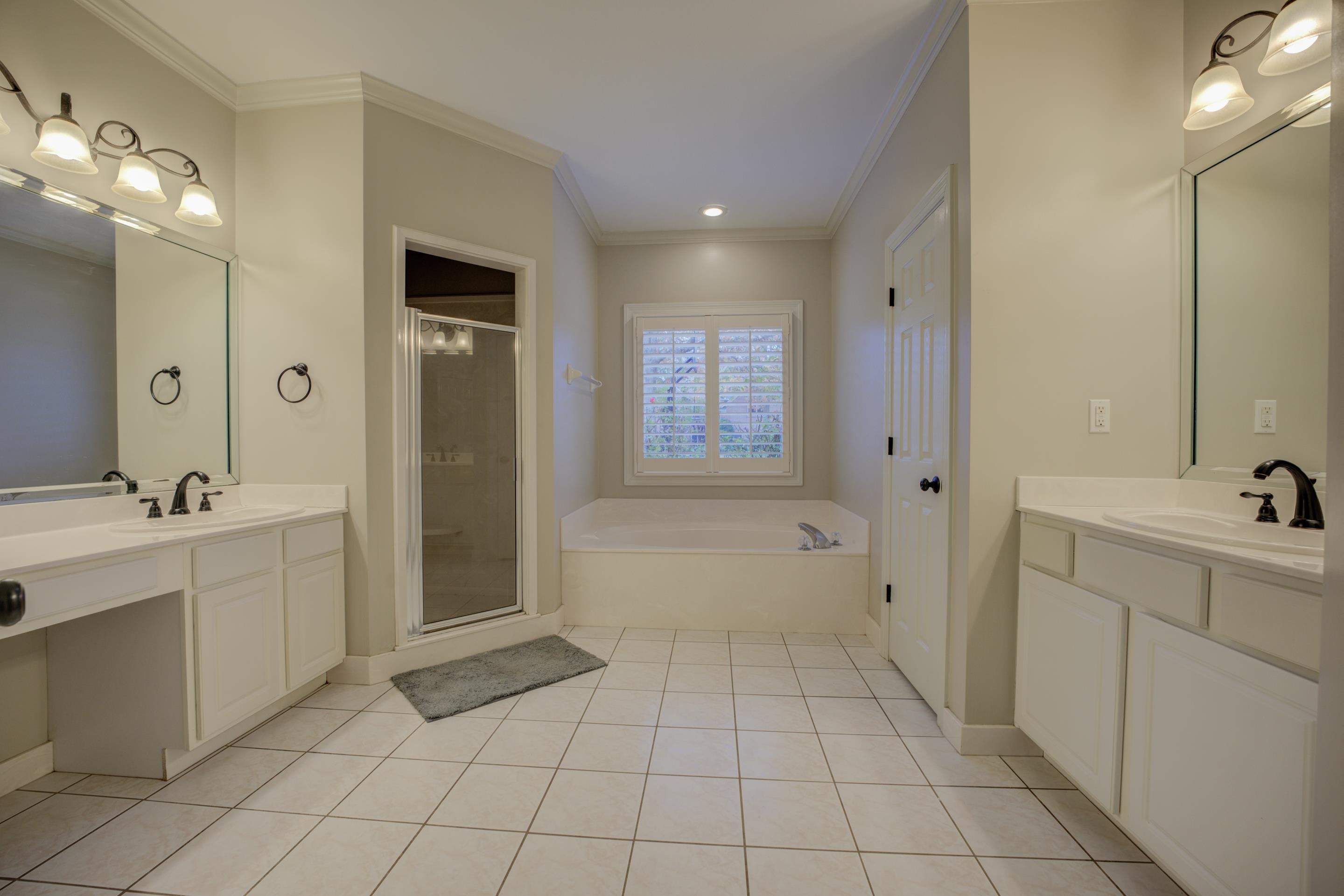 9852 Garden Place Collierville, TN 38139 - Photo 18 of 38 a spacious bathroom with a mirror a bathtub and a shower