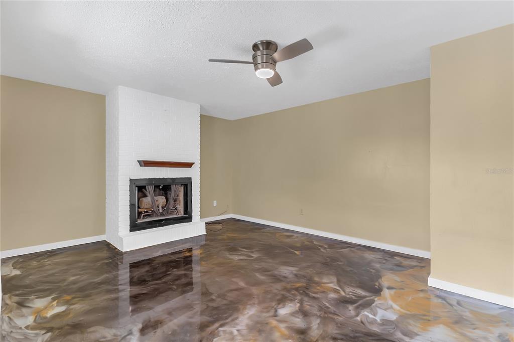 36 Springwood Square Port Orange, FL 32129 - Photo 12 of 31 a view of a livingroom with a fireplace and a ceiling fan