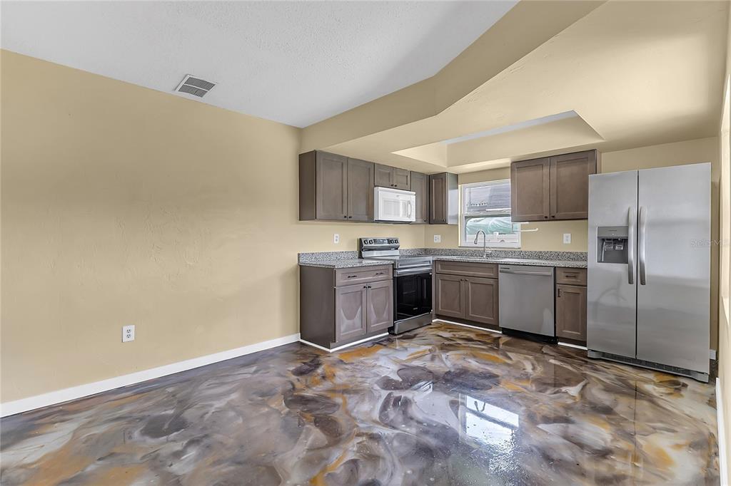 36 Springwood Square Port Orange, FL 32129 - Photo 15 of 31 a kitchen with a stove a sink and a refrigerator