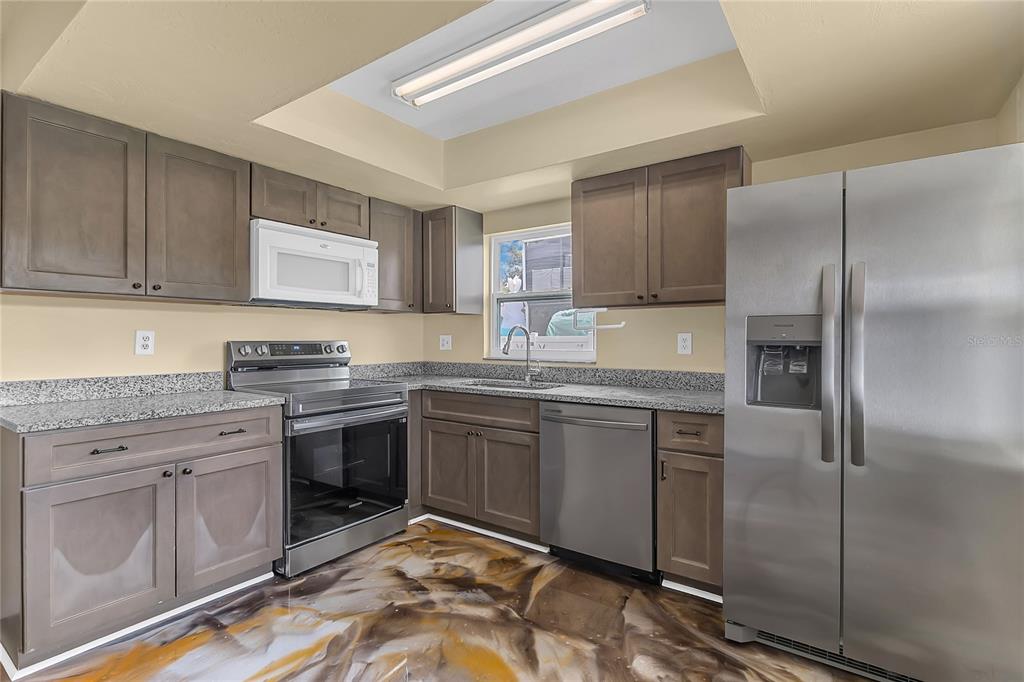 36 Springwood Square Port Orange, FL 32129 - Photo 16 of 31 a kitchen with stainless steel appliances granite countertop a refrigerator sink and cabinets