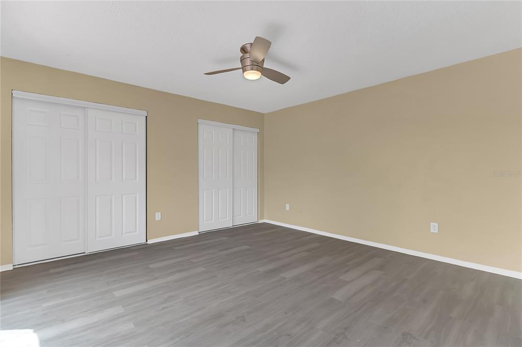 36 Springwood Square Port Orange, FL 32129 - Photo 18 of 31 a view of an empty room with wooden floor and a ceiling fan