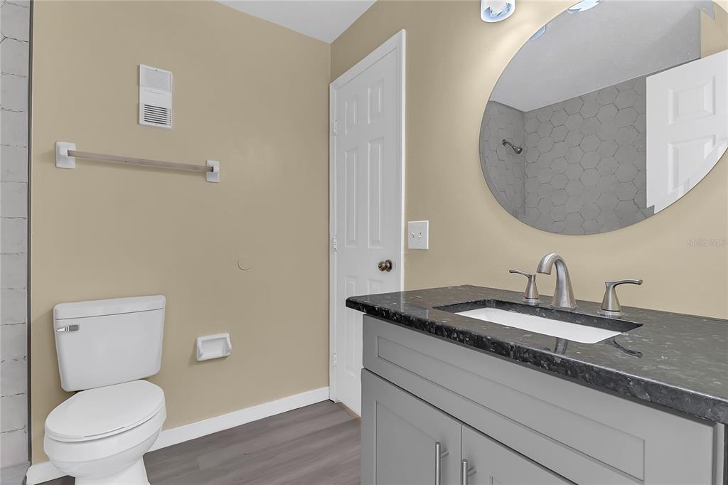 36 Springwood Square Port Orange, FL 32129 - Photo 19 of 31 a bathroom with a granite countertop toilet sink and mirror