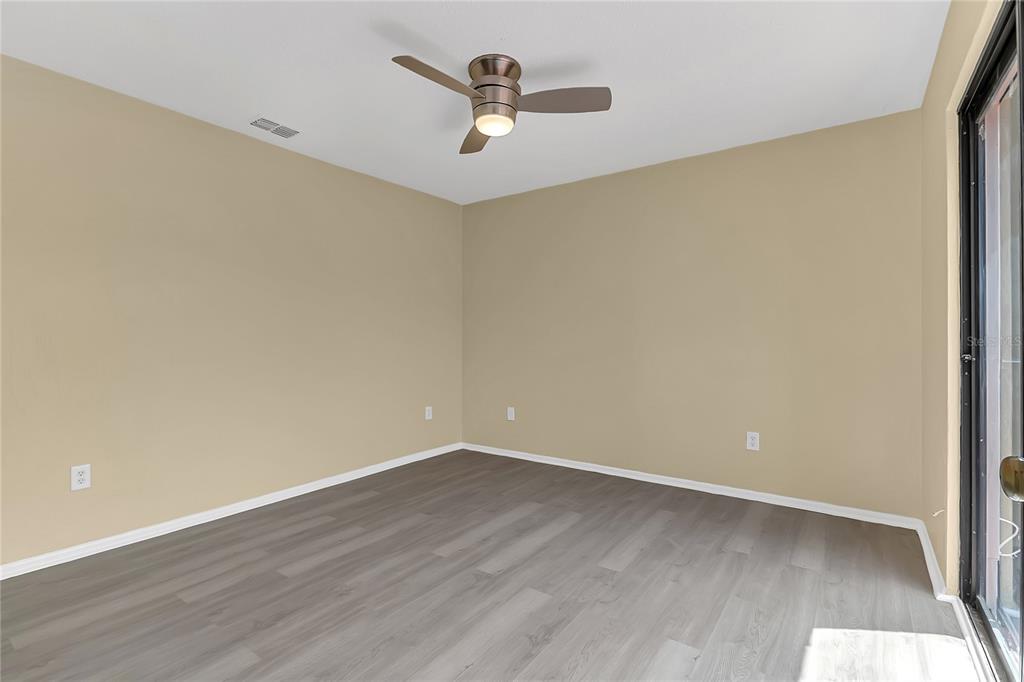 36 Springwood Square Port Orange, FL 32129 - Photo 22 of 31 a view of a room with wooden floor and a ceiling fan