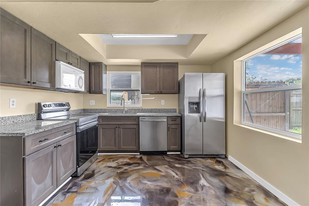 36 Springwood Square Port Orange, FL 32129 - Photo 4 of 31 a kitchen with granite countertop a refrigerator stove top oven and sink