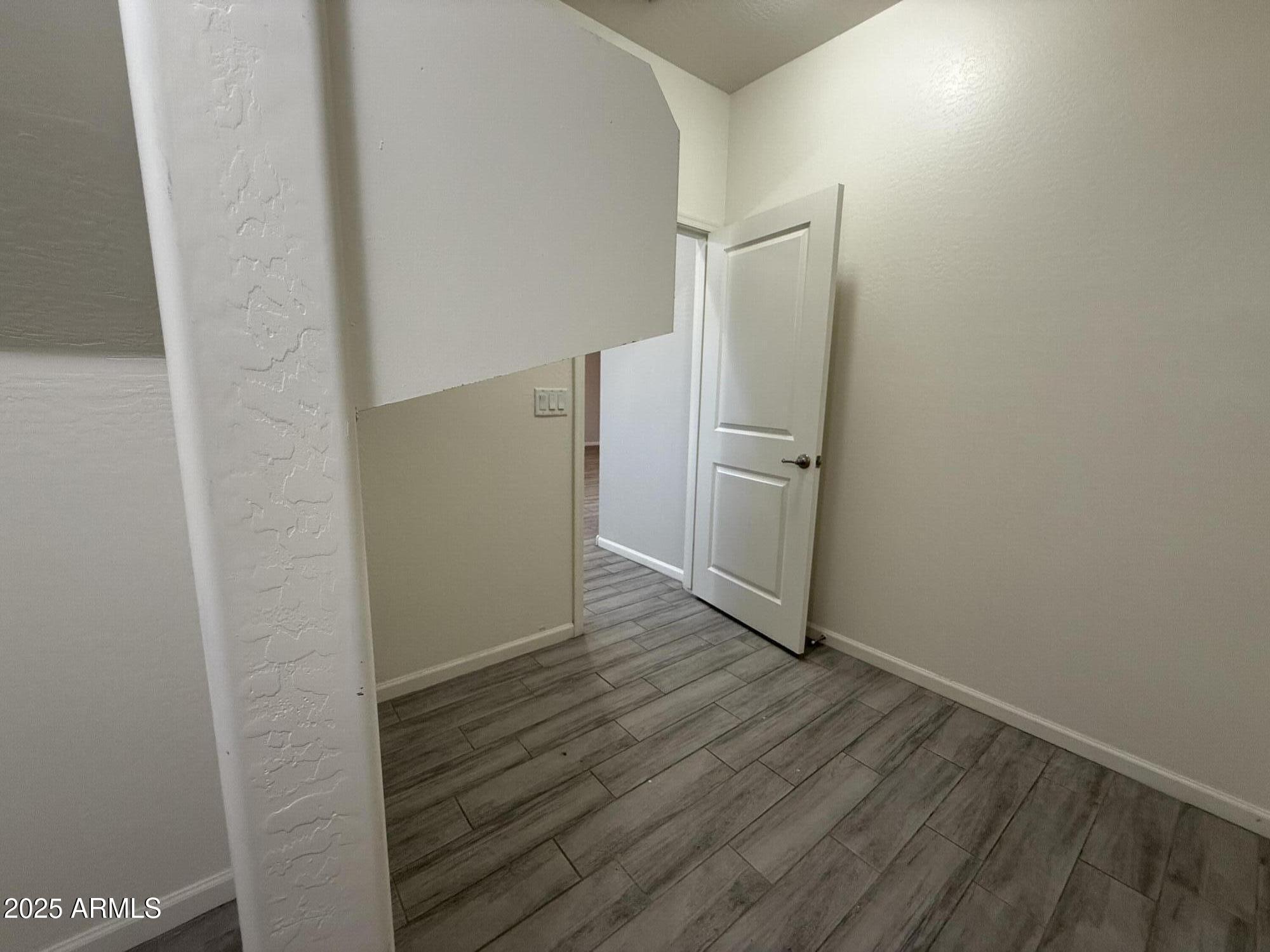 1743 West Pollack Street Phoenix, AZ 85041 - Photo 11 of 46 a view of an empty room with wooden floor and closet