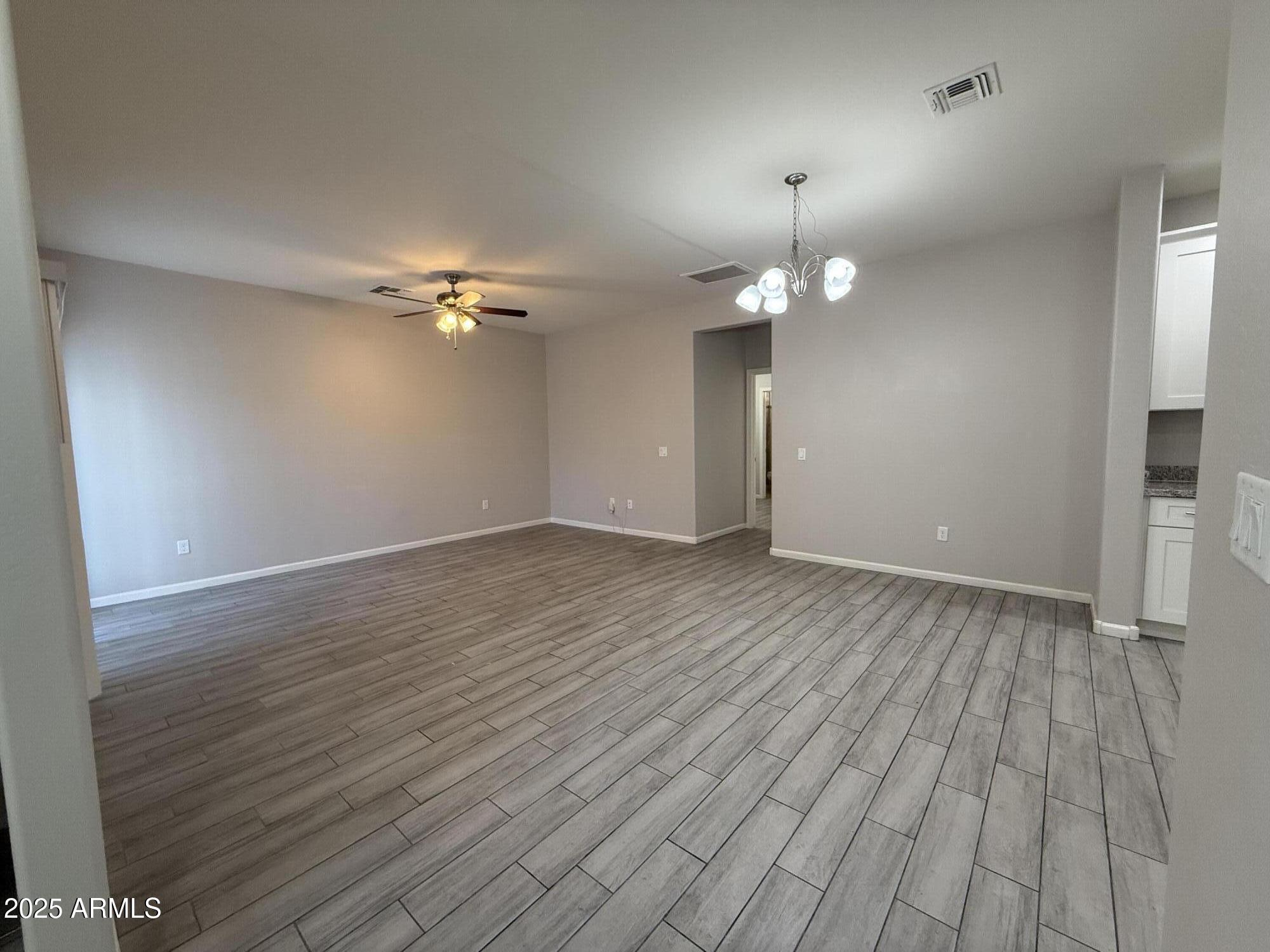 1743 West Pollack Street Phoenix, AZ 85041 - Photo 12 of 46 a view of an empty room with wooden floor