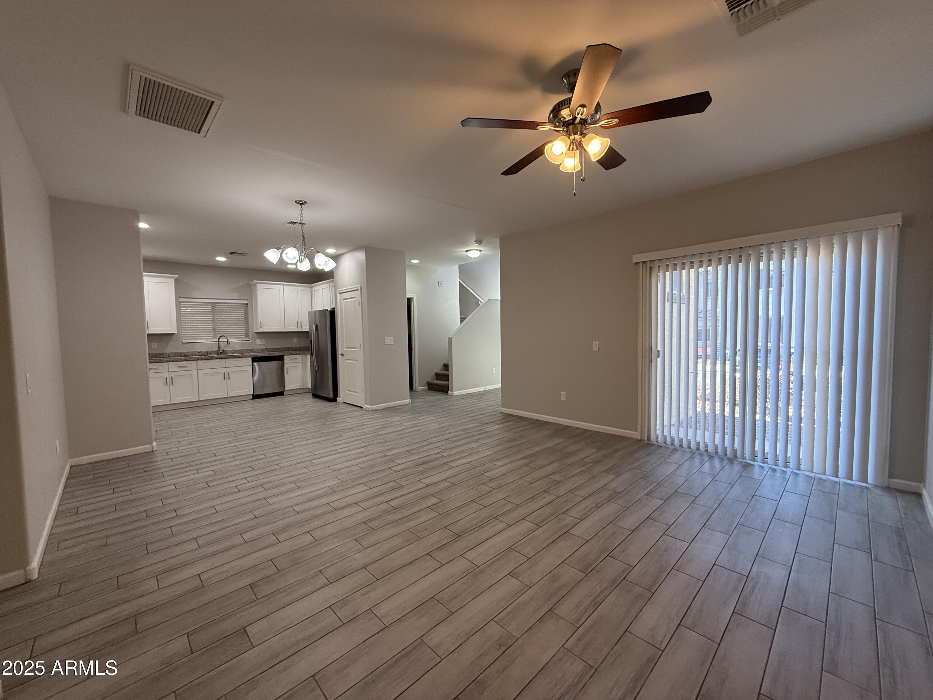 1743 West Pollack Street Phoenix, AZ 85041 - Photo 13 of 46 a view of an empty room with wooden floor and a ceiling fan