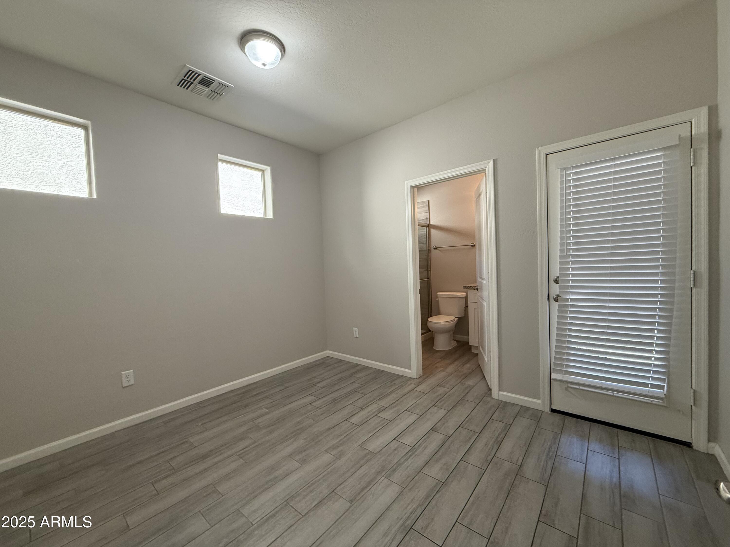 1743 West Pollack Street Phoenix, AZ 85041 - Photo 22 of 46 an empty room with wooden floor and closet