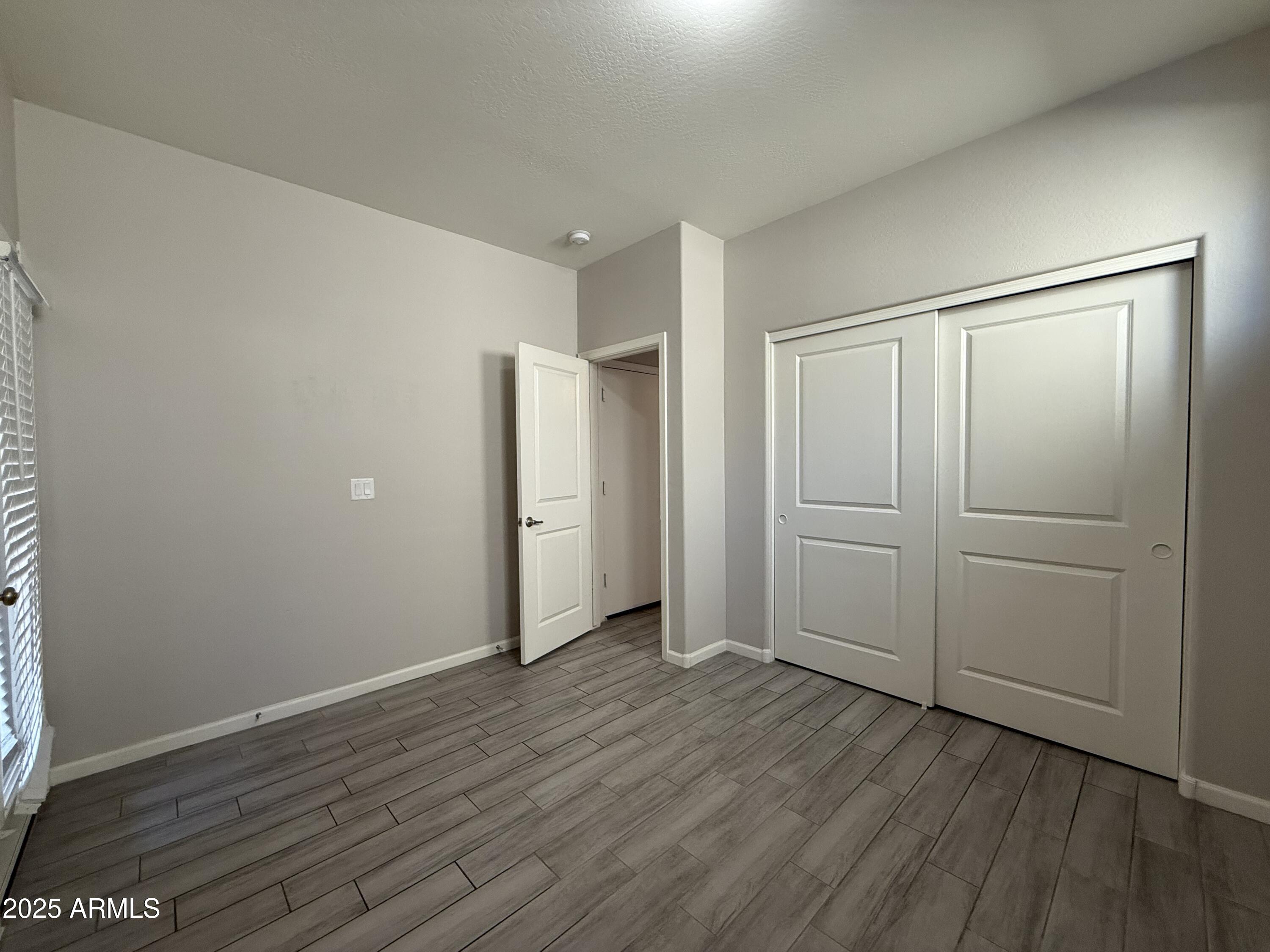 1743 West Pollack Street Phoenix, AZ 85041 - Photo 23 of 46 a view of an empty room with wooden floor