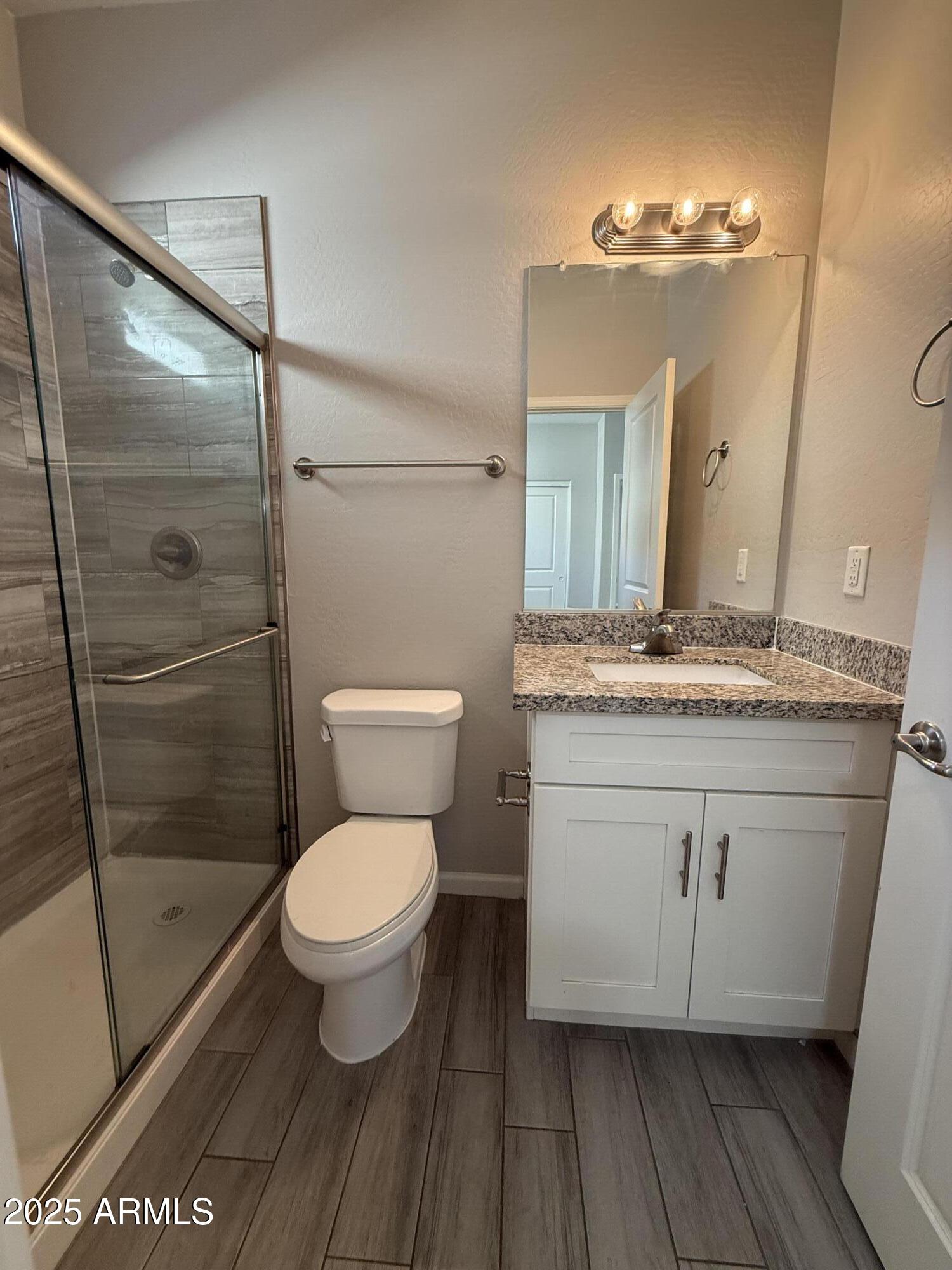1743 West Pollack Street Phoenix, AZ 85041 - Photo 25 of 46 a bathroom with a granite countertop toilet a sink and a mirror