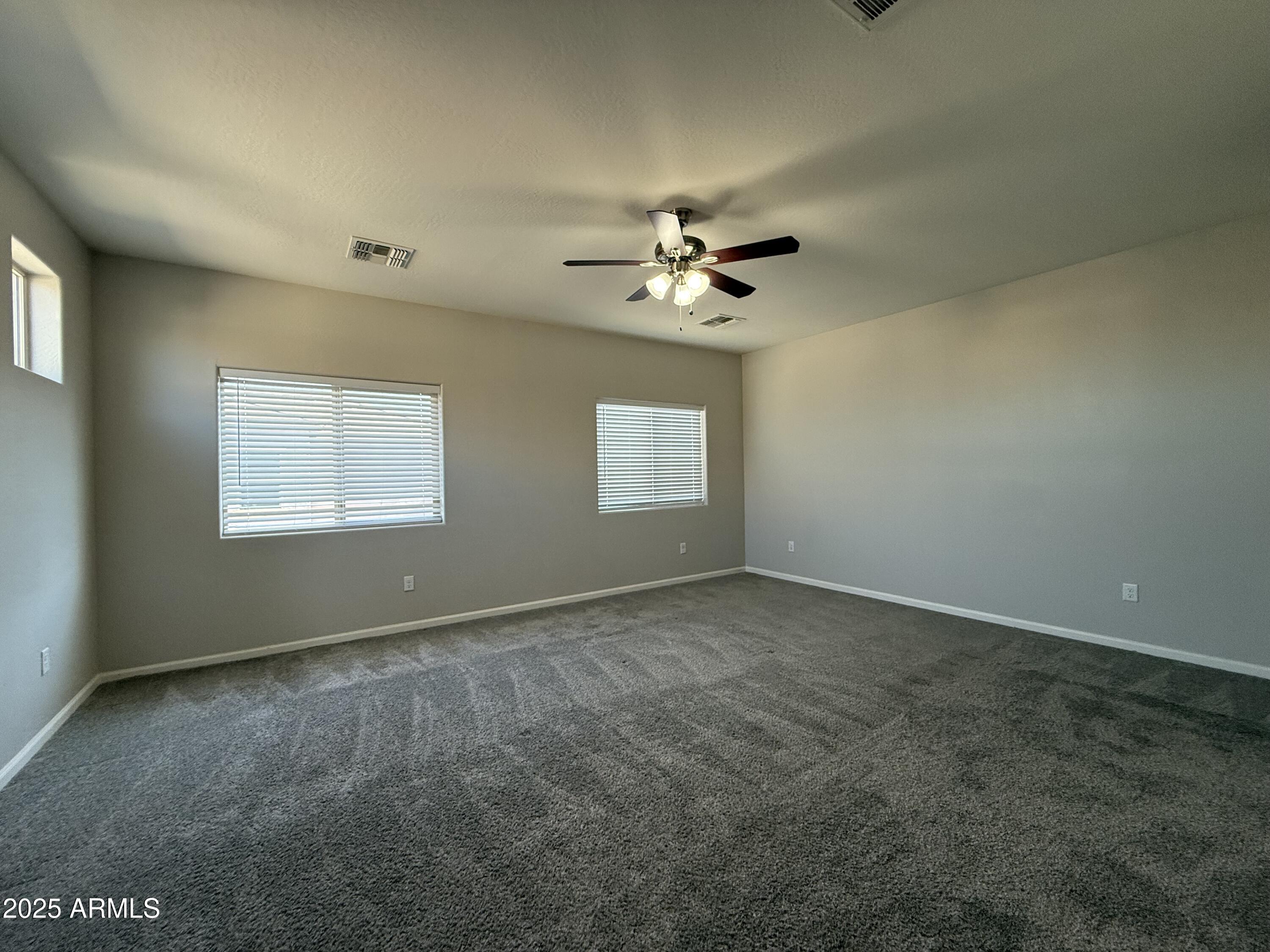 1743 West Pollack Street Phoenix, AZ 85041 - Photo 39 of 46 an empty room with windows and chandelier fan