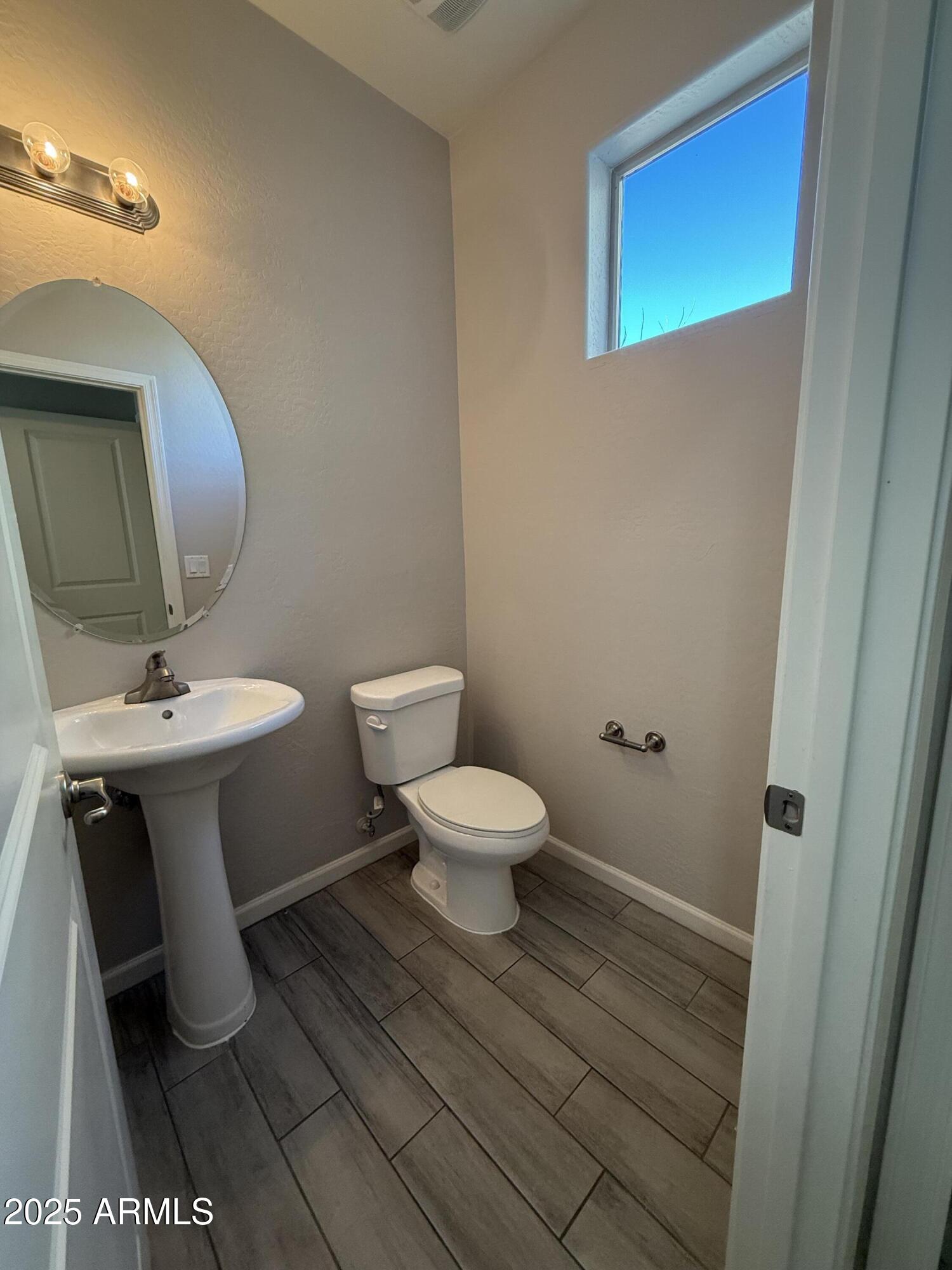 1743 West Pollack Street Phoenix, AZ 85041 - Photo 5 of 46 a bathroom with a toilet a sink and mirror