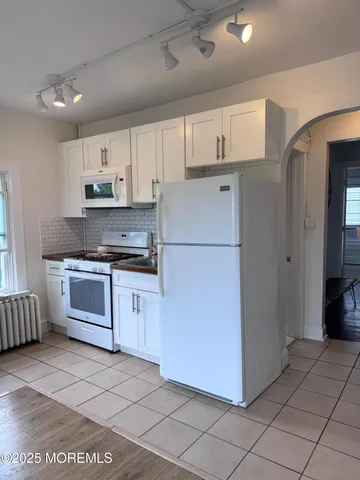 a view of a hallway with wooden floor and workspace