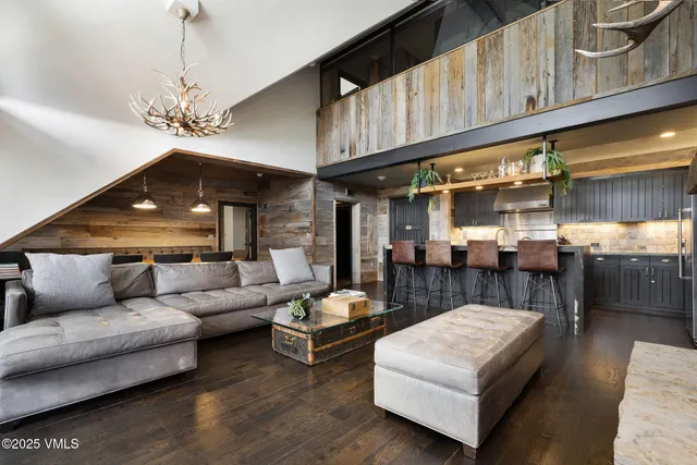 a living room with furniture a chandelier and a fireplace