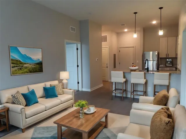 a living room with furniture and kitchen view