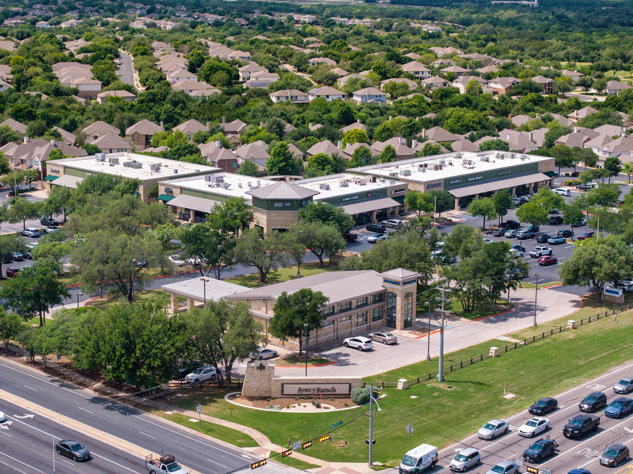 14815 Avery Ranch Boulevard, Unit 1401 Austin, TX 78717 - Photo 37 of 38 Commercial buildings featuring stone and stucco exteriors, multiple storefronts, and ample paved parking