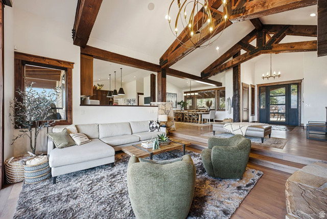 7885 North Rabbitbrush Court, Unit 13 Park City, UT 84098 - Photo 9 of 88 Vaulted ceilings with exposed wood beams define this spacious living area, featuring wood-finish flooring and a stone fireplace