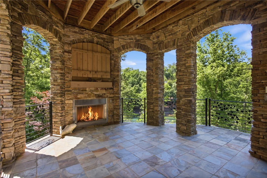 130 River Ridge Road Sunset, SC 29685 - Photo 37 of 47 An inviting stone-clad patio provides an outdoor fireplace and scenic tree-lined views, perfect for relaxation.
