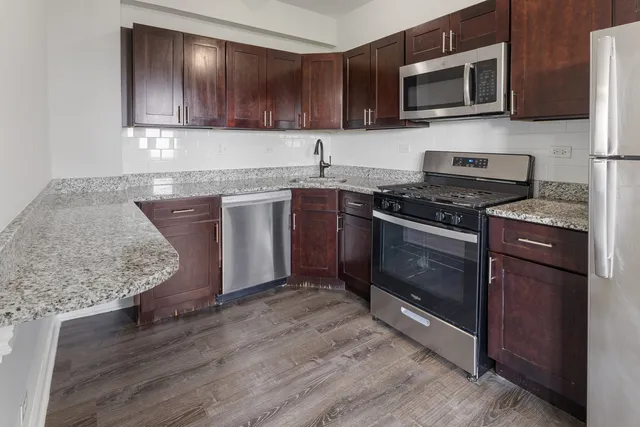 a kitchen with stainless steel appliances granite countertop a stove microwave and sink