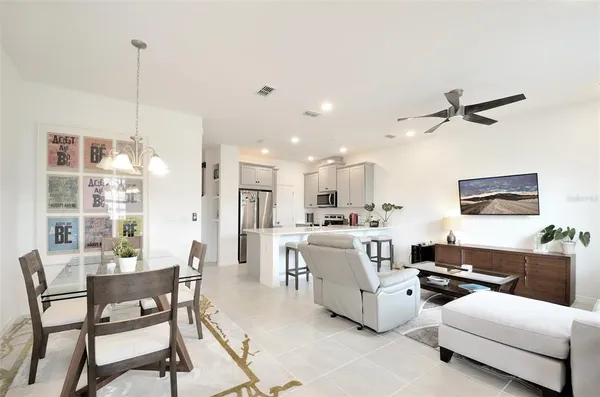 a living room with furniture kitchen view and a chandelier