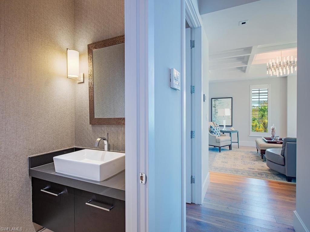490 5th Street South, Unit 101 Naples, FL 34102 - Photo 20 of 34 a en suite bathroom with a sink a mirror and a toilet