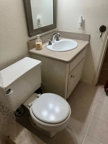 a bathroom with a sink mirror and toilet