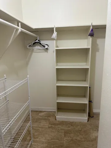 a view of walk in closet with empty racks