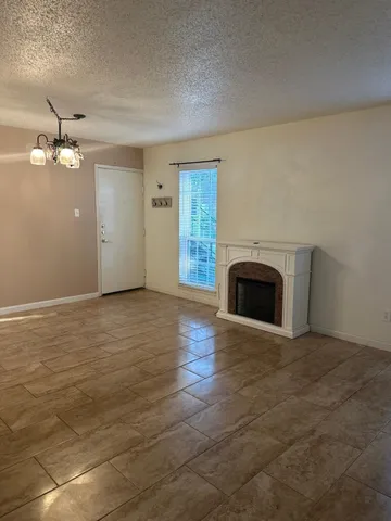an empty room with kitchen view with fireplace