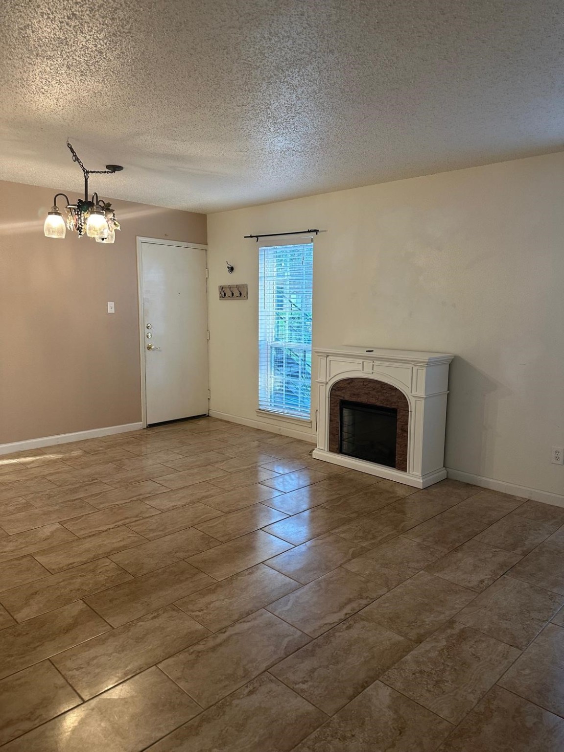 6410 Del Monte Drive, Unit 114 Houston, TX 77057 - Photo 5 of 27 an empty room with kitchen view with fireplace