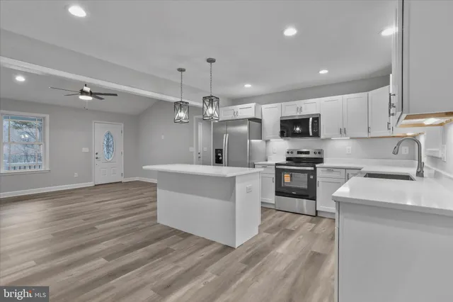 a large kitchen with lots of counter space wooden floor and appliances