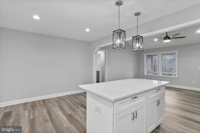 a view of a kitchen with a sink and dishwasher a kitchen view with wooden floor