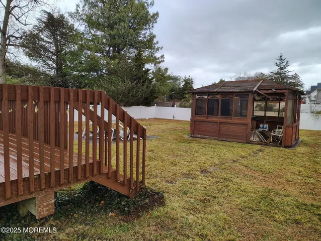 a view of a house with backyard and wooden fence