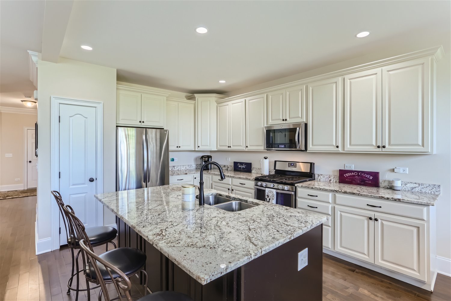 1239 Falcon Ridge Drive Elgin, IL 60124 - Photo 8 of 28 a kitchen with stainless steel appliances granite countertop a kitchen island hardwood floor sink stove and white cabinets